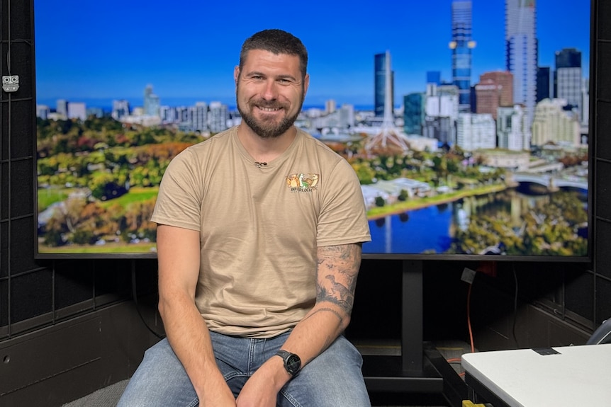 Scientist sitting in front of a television screen.