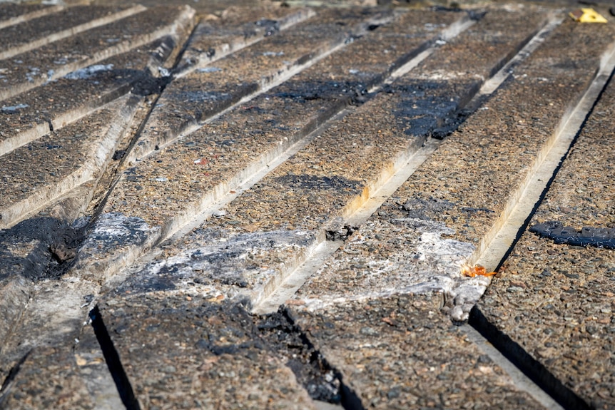 Dark patches of burnt rubber on concrete.