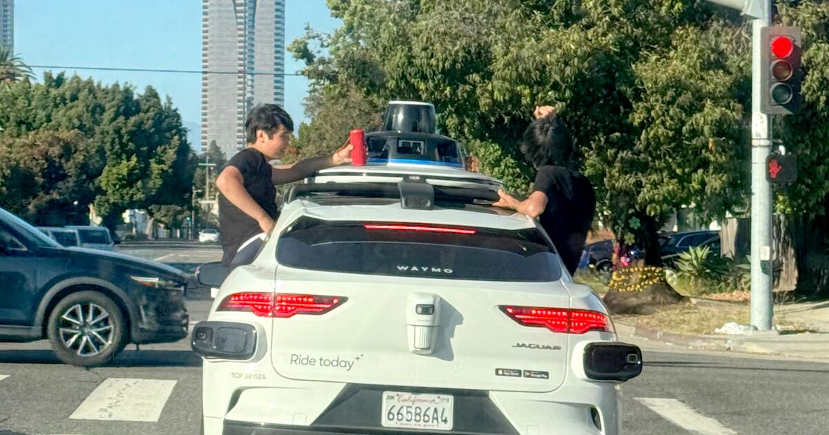Teens sit in windows as Waymo travels through Westside