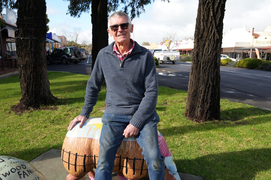 man sitting on a sheep statue