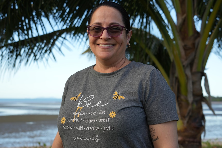 A woman wearing a t shirt smiling at the camera