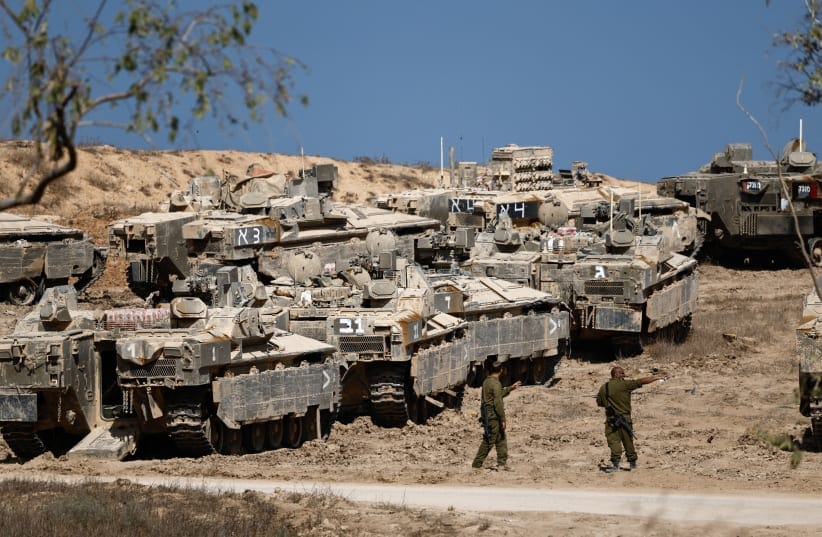 Israeli soldiers stand next to armored personnel carriers (APCs) near the Gaza border, in Israel, September 16, 2025