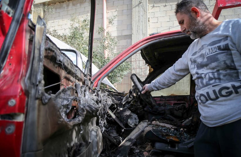 Palestinians inspect the burned remains of a vehicle after a settler attack in the Beit Fajjar town, south of Bethlehem, January 27, 2026.