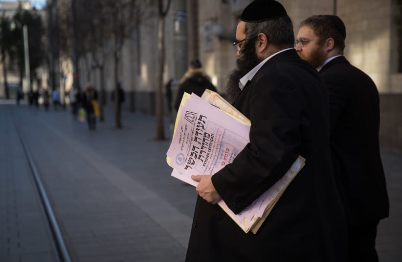 REPRESENTATIVES OF the Chief Rabbinate of Israel cross Jaffa Street in Jerusalem as they deliver a kosher certificate to a local restaurant.