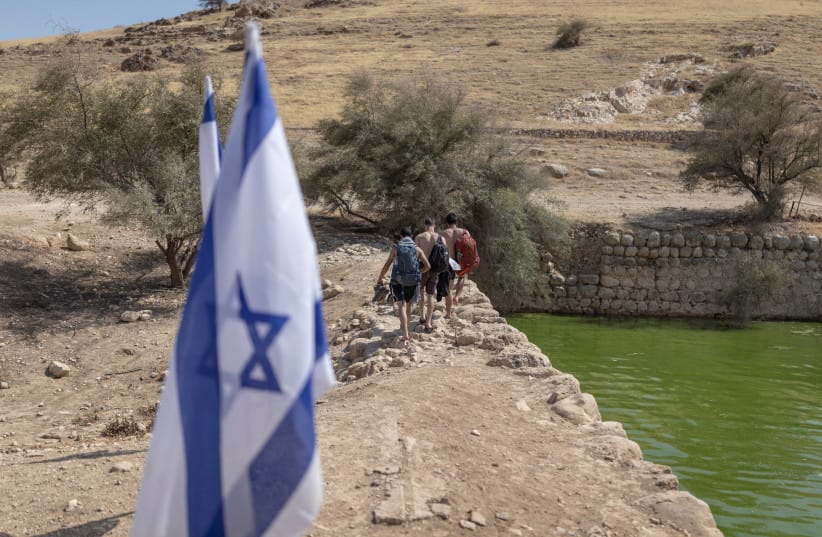 Israeli walks along the edge of the ancient archaeological site of ''Herod's Pool'' near the Jewish settlement of Petzael, in the Israeli occupied Palestinian West Bank, in the Jordan Valley, after water was recently diverted into the site from a nearby spring on June 15, 2026.