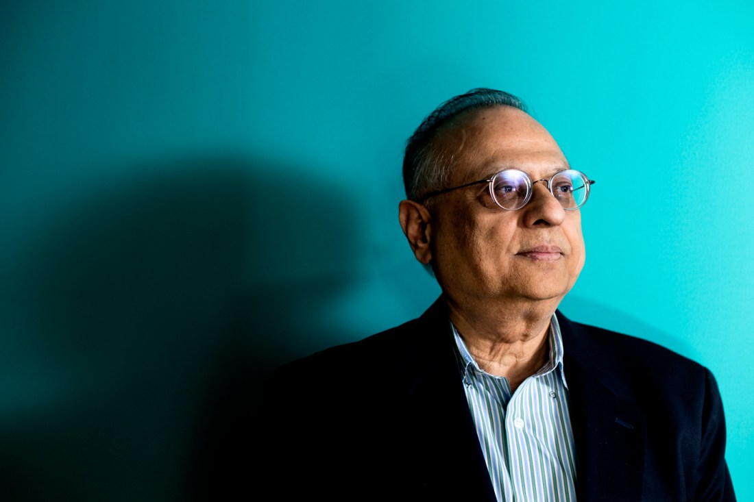 Arun Bansil, University Distinguished Professor of physics at Northeastern University, in a studio portrait against a teal backdrop.