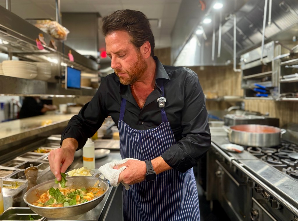 Chef Scott Conant finishes gnocchi with fresh chopped basil.