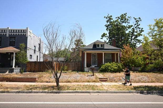 Pedestrians walk along Corona Street past homes where vegetation, including a tree, has died because of the ongoing drought on Tuesday, July 21, 2026, in Denver. (Photo by RJ Sangosti/The Denver Post)