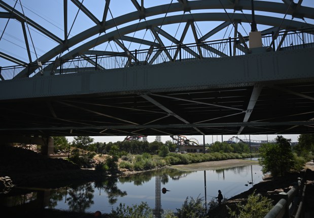 A man fishes beneath a bridge along the South Platte River on Tuesday, July 21, 2026, in Denver. The river is running low because of the ongoing drought and record-low snowpack in Colorado's mountains. (Photo by RJ Sangosti/The Denver Post)