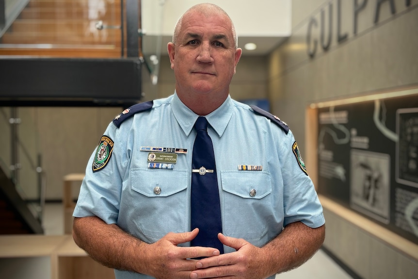 A police officer looks at the camera at the station