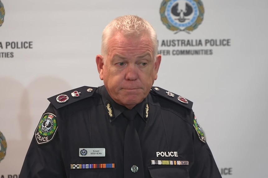 Grant Stevens in police uniform in front of SA Police banner