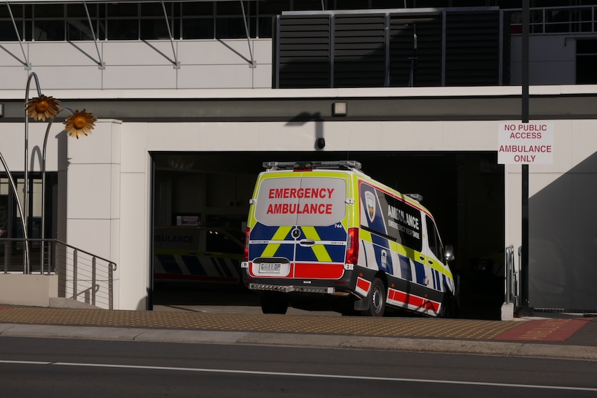 An ambulance enters a roller door into a hospital.