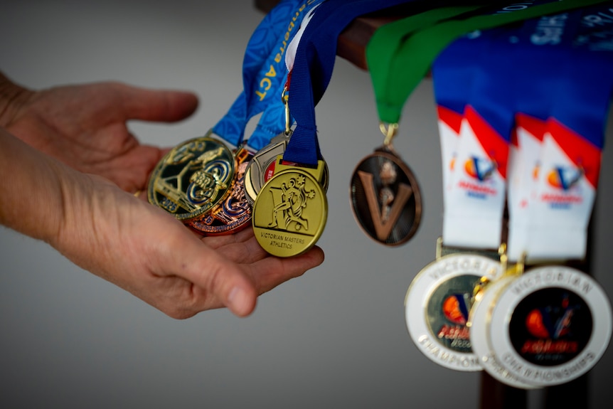 A person touching medals.