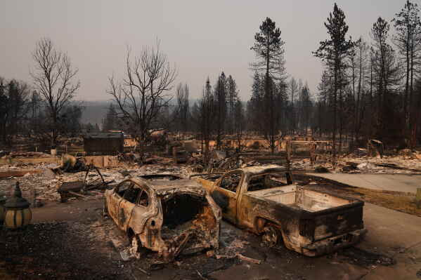Dozens of homes are seen burned to the ground after a wildfire hit the northern part of Spokane, Wash., Monday, Aug. 3, 2026. (AP Photo/Lindsey Wasson)