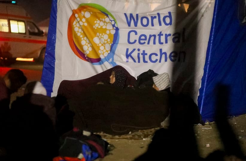 People sit in front of a World Central Kitchen in Deir al-Balah, Gaza Strip, on January 26, 2025.