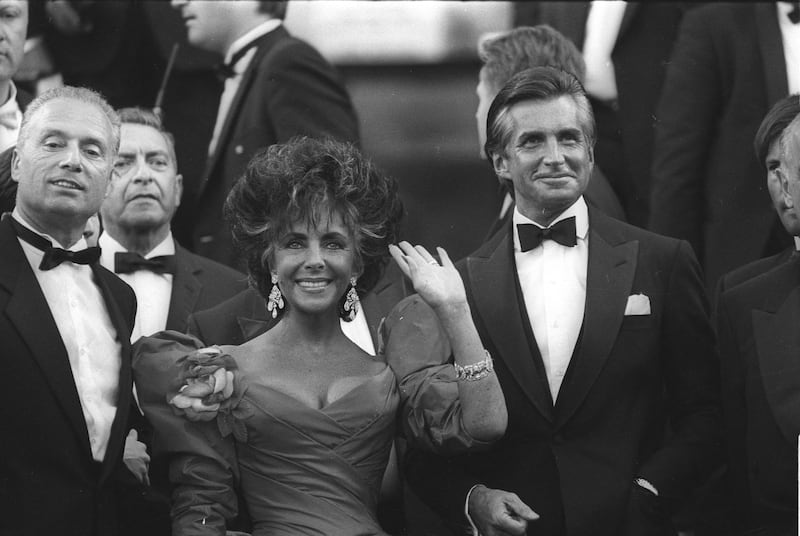 Actress Elizabeth Taylor and actor George Hamilton arrive at the 40th Anniversary ceremony of the Cannes Film Festival on May 13, 1987.