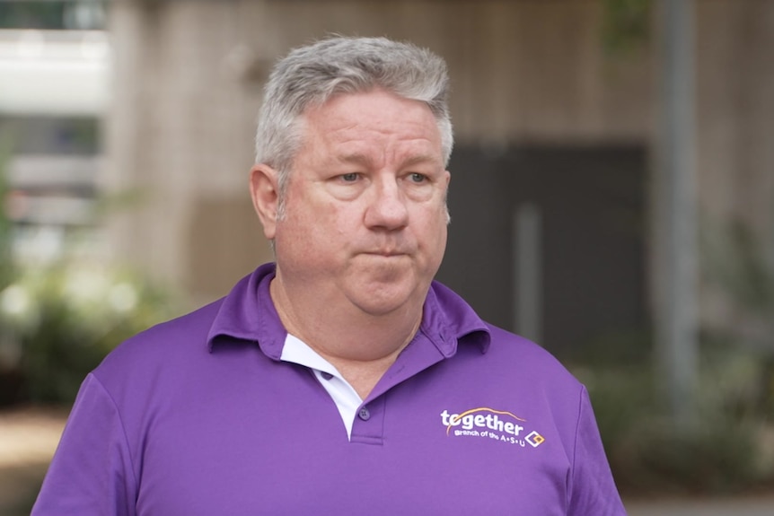 A man with grey hair in a purple union shirt