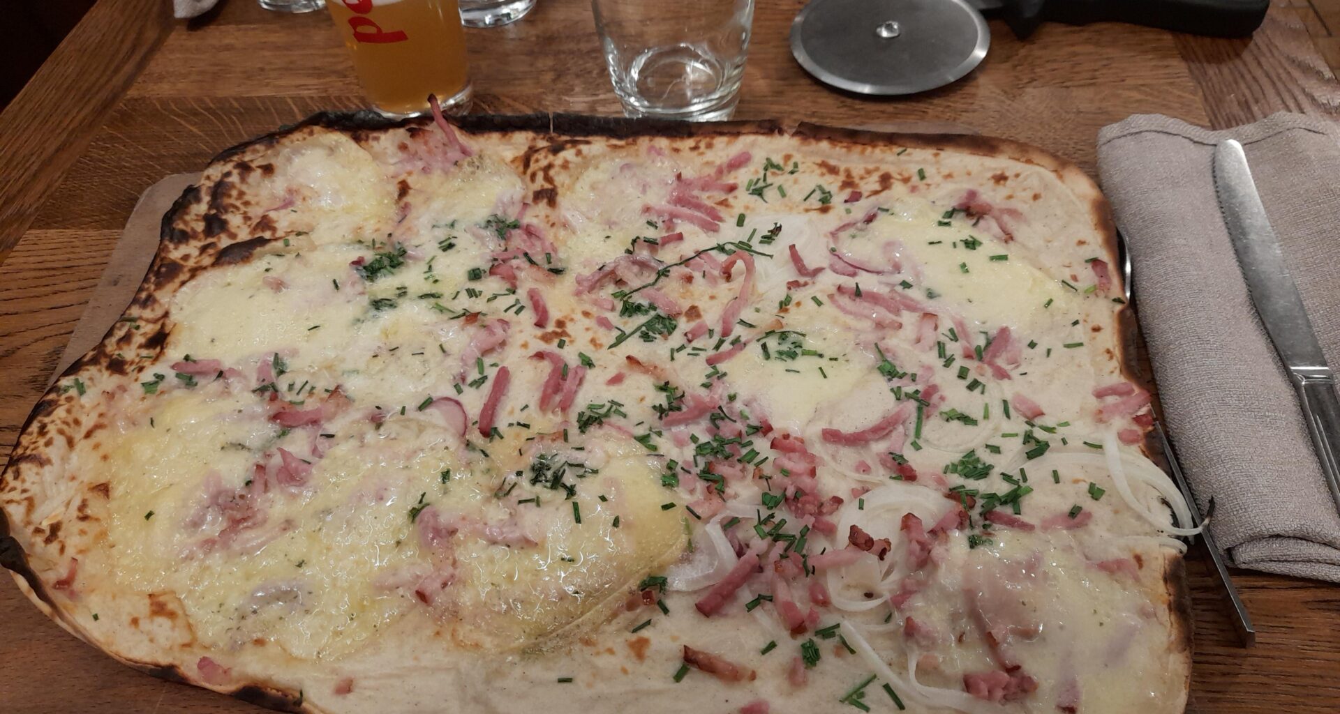 Tarte flambée gratinée à la tomme et au munster