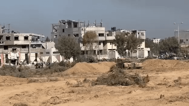 Gaza residents from Zaytun neighborhood walking south through the humanitarian corridor established by the IDF, notice the tanks keeping them safe, while some Gazan some of the people holding white flags.