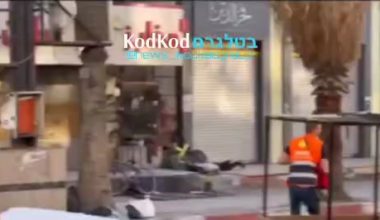 A paramedic in Jenin passing a firearm from a dead terrorist to a live one
