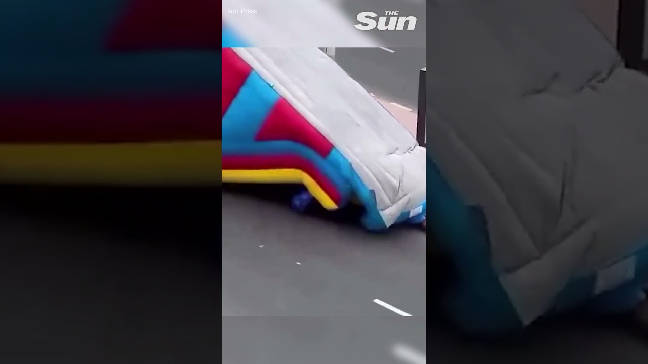 Kids dragged as bouncy slide blows into busy oncoming traffic