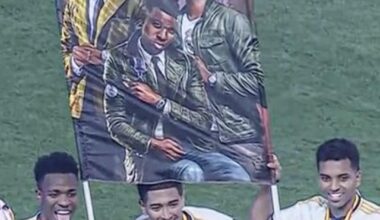 Bellingham, Vinicius, and Rodrygo posing with the Supercopa and a fan’s poster