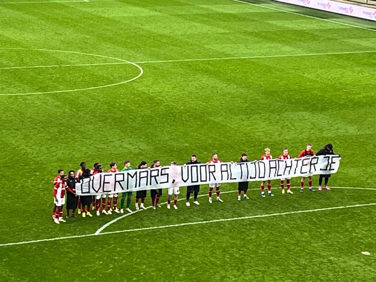 Royal Antwerp players holding a banner after the game in support of Marc Overmars, who has been suspended by FIFA for his inappropriate behaviour towards women at Ajax: "Overmars, always behind you".