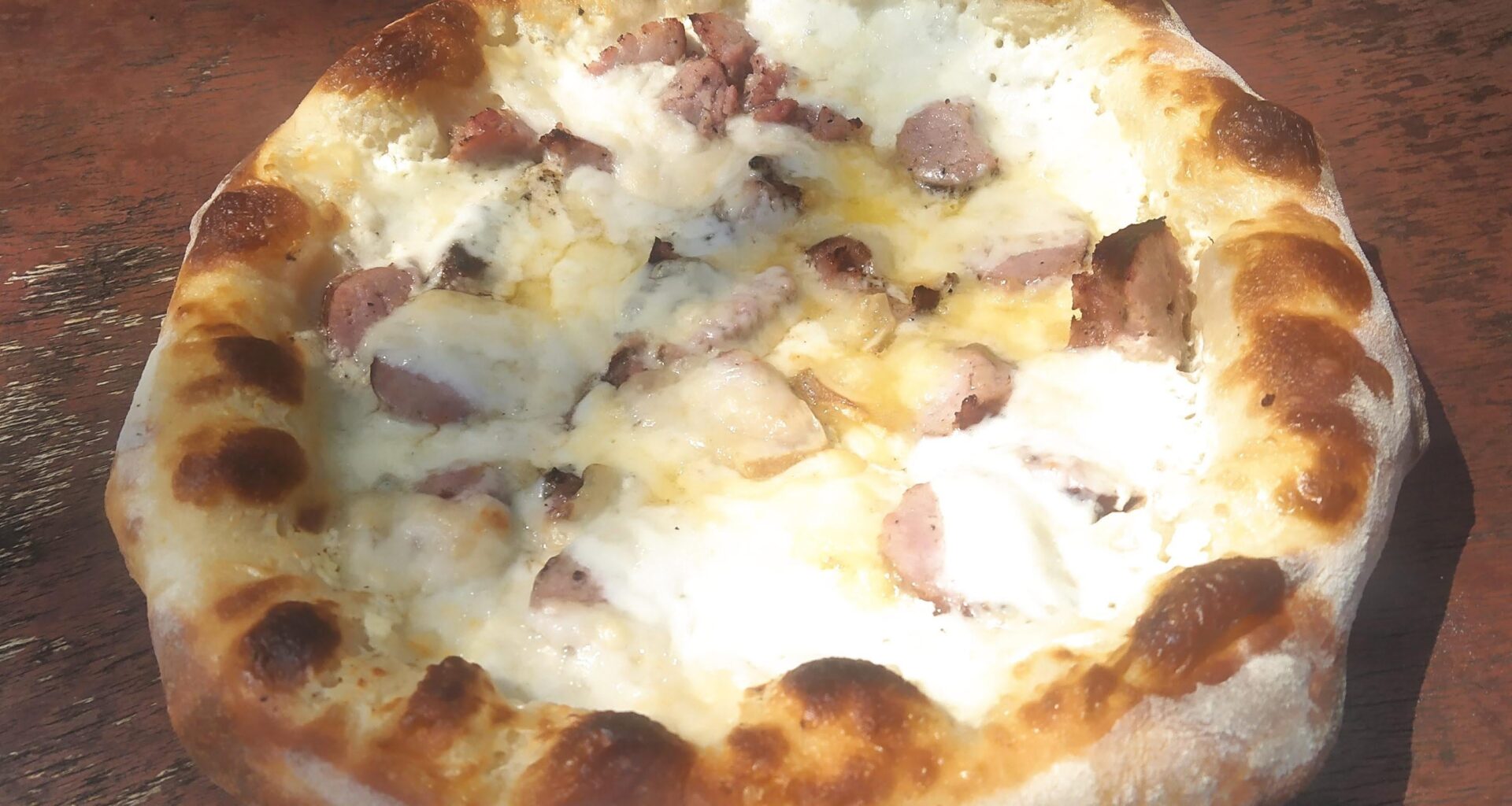 Pizza des causses. Fromages de brebis, chèvre & vache - crème - saucisse de Toulouse.