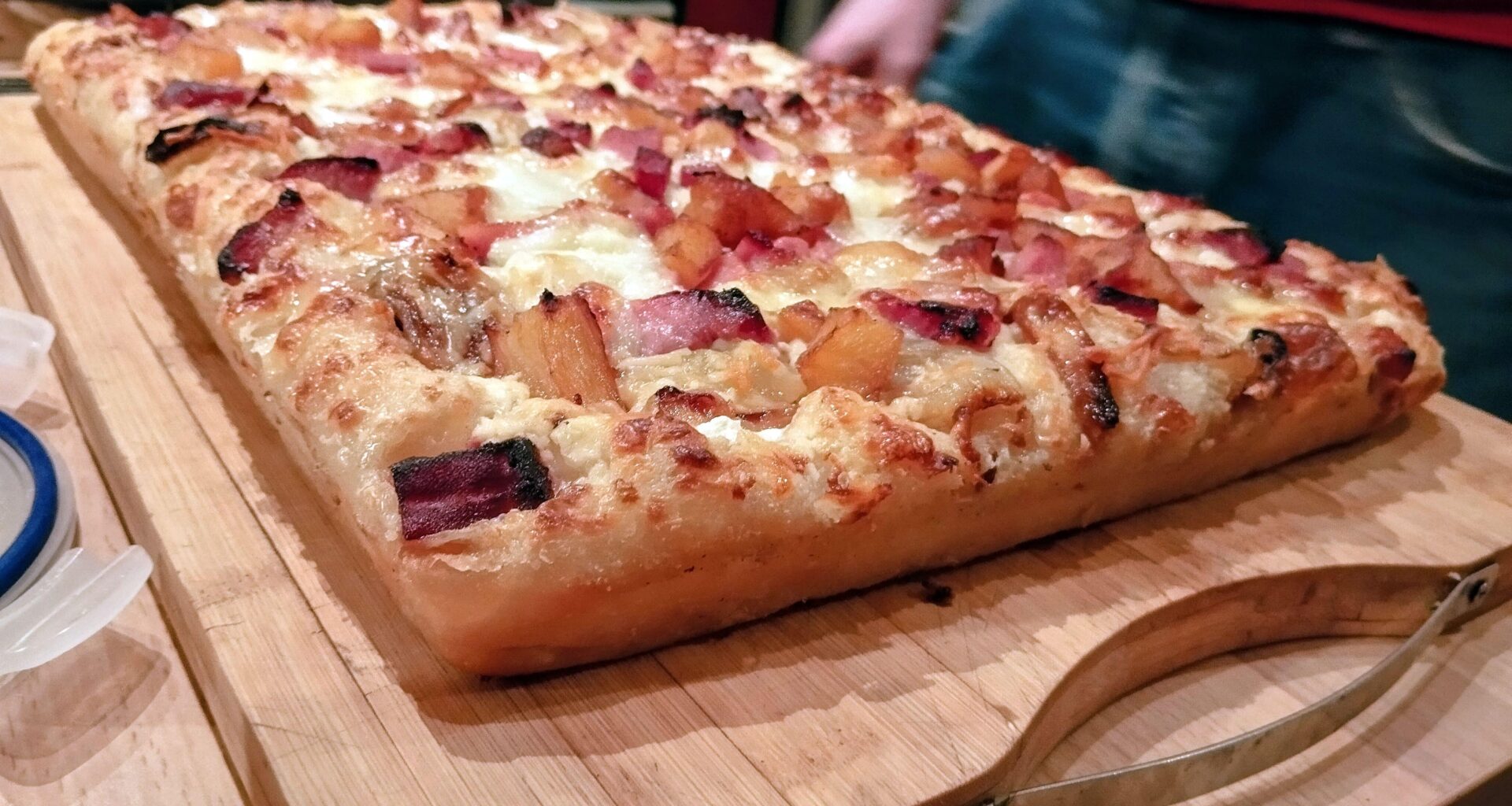 Pizza "detroit style" - jambonneau fumé de Morteau rôti au miel et ananas - crème d'Isigny - mozzarella râpée et parmesan.
