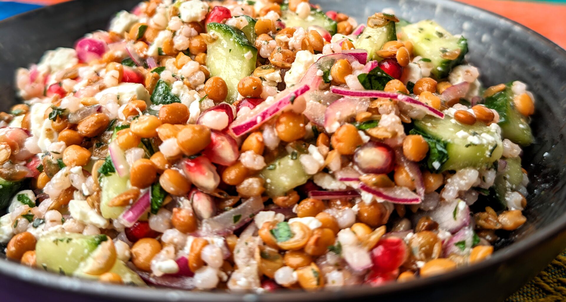 Lentil salad with pearl barley, cucumber, pomegranate seeds, red onion, feta cheese, balsamico bianco, salt, flat parsley and thyme.
