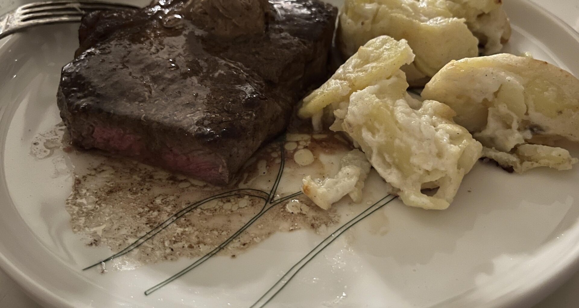 Strip steak, pommes au gratin and black garlic butter.