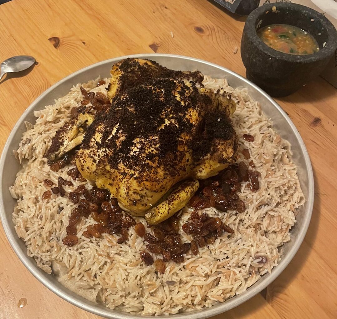 Gazan-style stuffed roast chicken with sumac over seasoned rice with raisins
