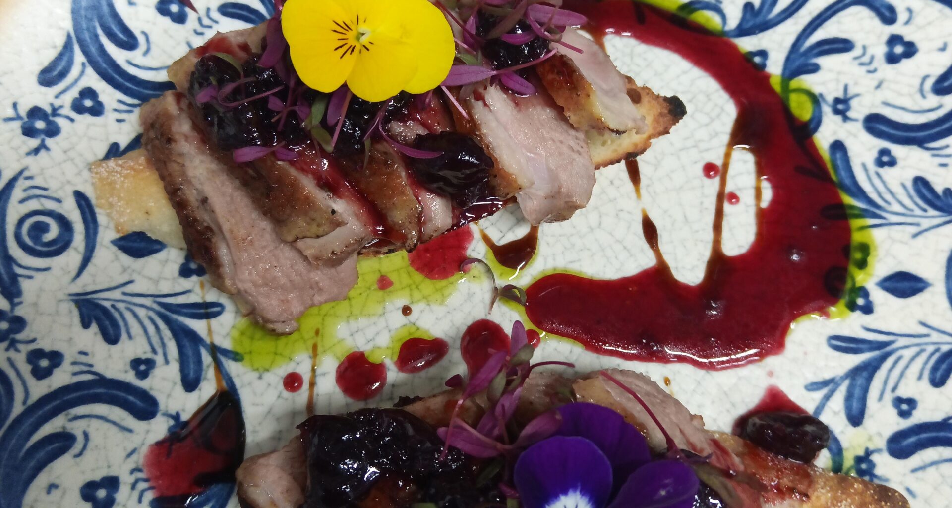 Bruschetta de magret de canard sous vide, sauce de cerises épicée.