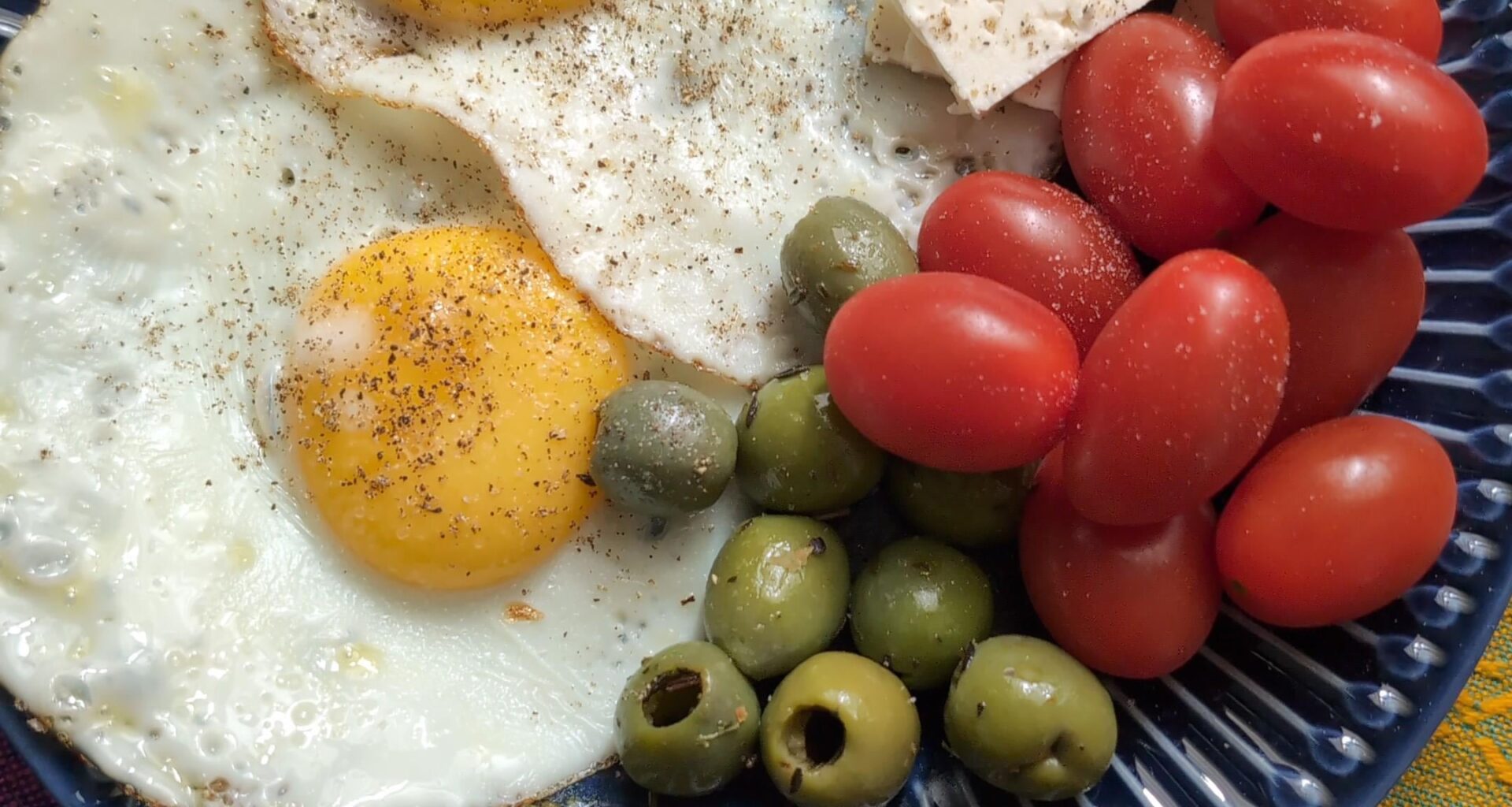 Fried eggs with olives, tomatoes and feta.