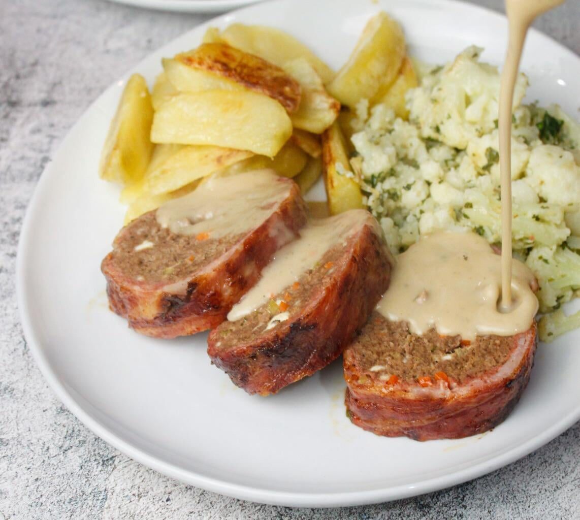 Meatloaf with feta cheese & vegetables wrapped in bacon, served with roast potatoes, cauliflower tossed in herbs and a pepper sauce
