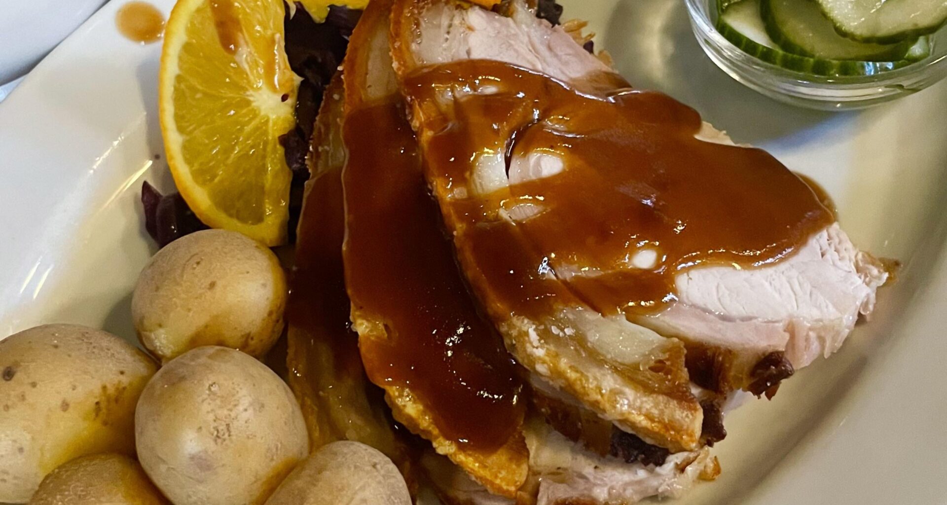 Danish style roast pork with boiled potatoes, red cabbage, and cucumber salad in Copenhagen