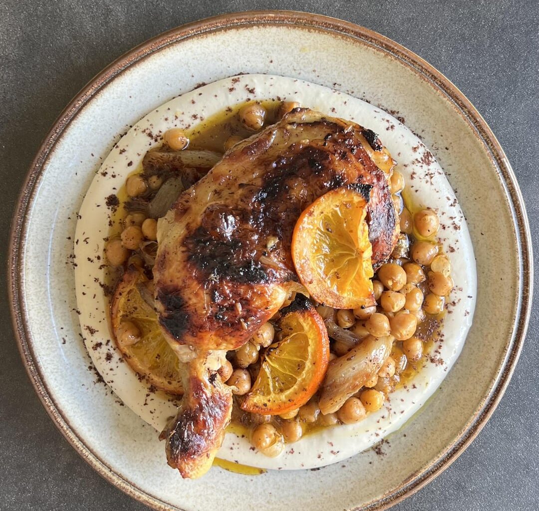 Cuisse de poulet à l’orange et harissa, échalotes rôties, pois-chiches, sauce citron tahini