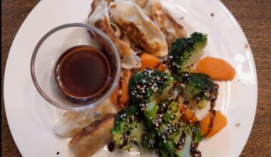 Vegetarian dumplings with soy and rice wine vinegar dipping sauce, steamed broccoli and carrot with hoi sin, garlic, salt and sesame seeds.