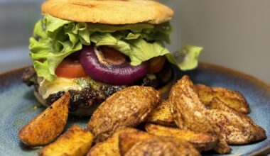 Homemade beef burger with chimichurri, cheddar, tomato, roasted onion and air fried potatoes