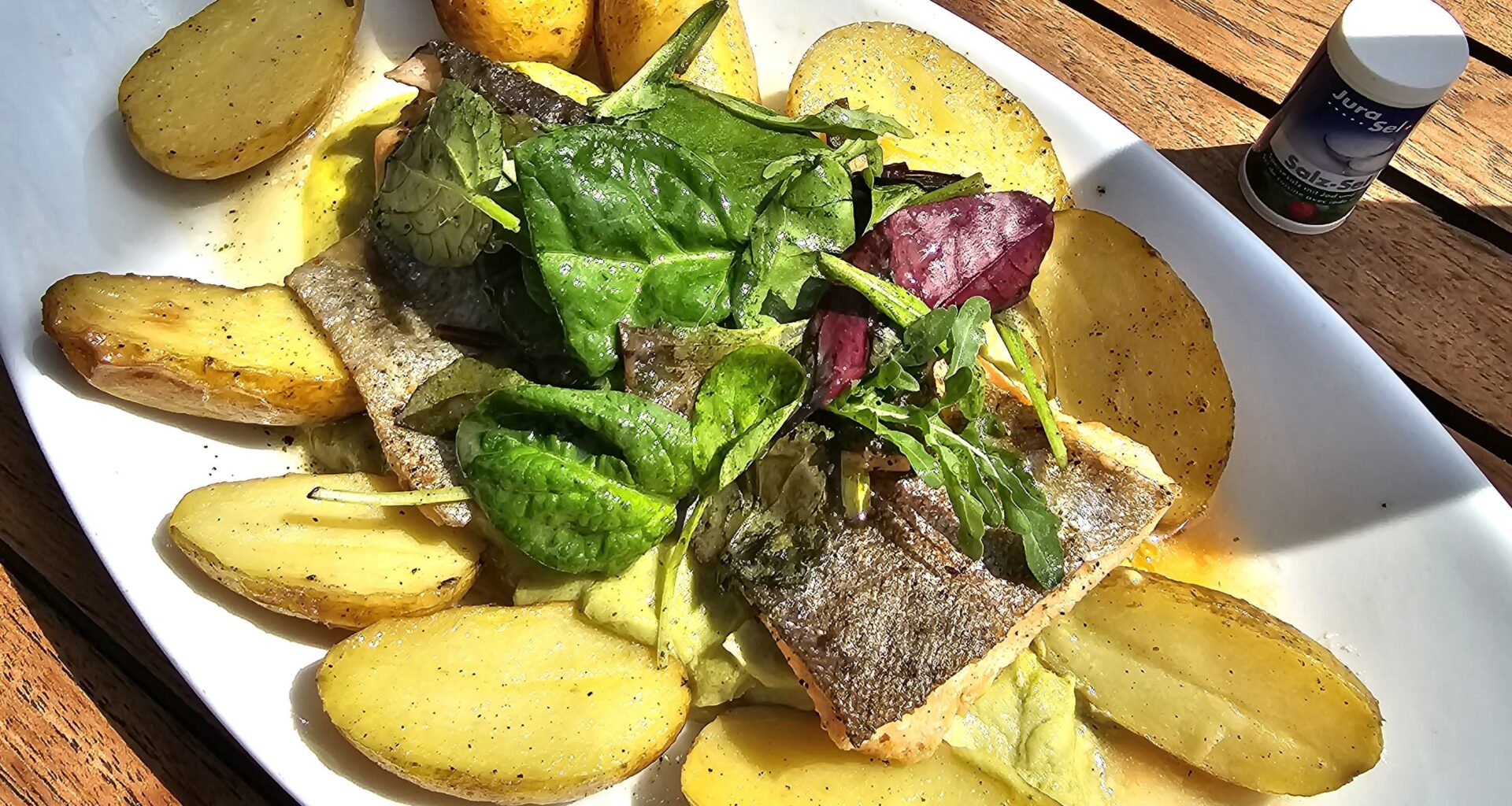 Fried salmon trout fillet on broccoli and lime cream with rosemary butter and swivel potatoes; served in Allensbach, Lake Constance, Germany