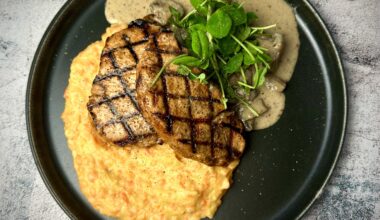 Grilled pork chops on mashed potatoes & carrots served with mushrooms stewed in a cream sauce with horseradish