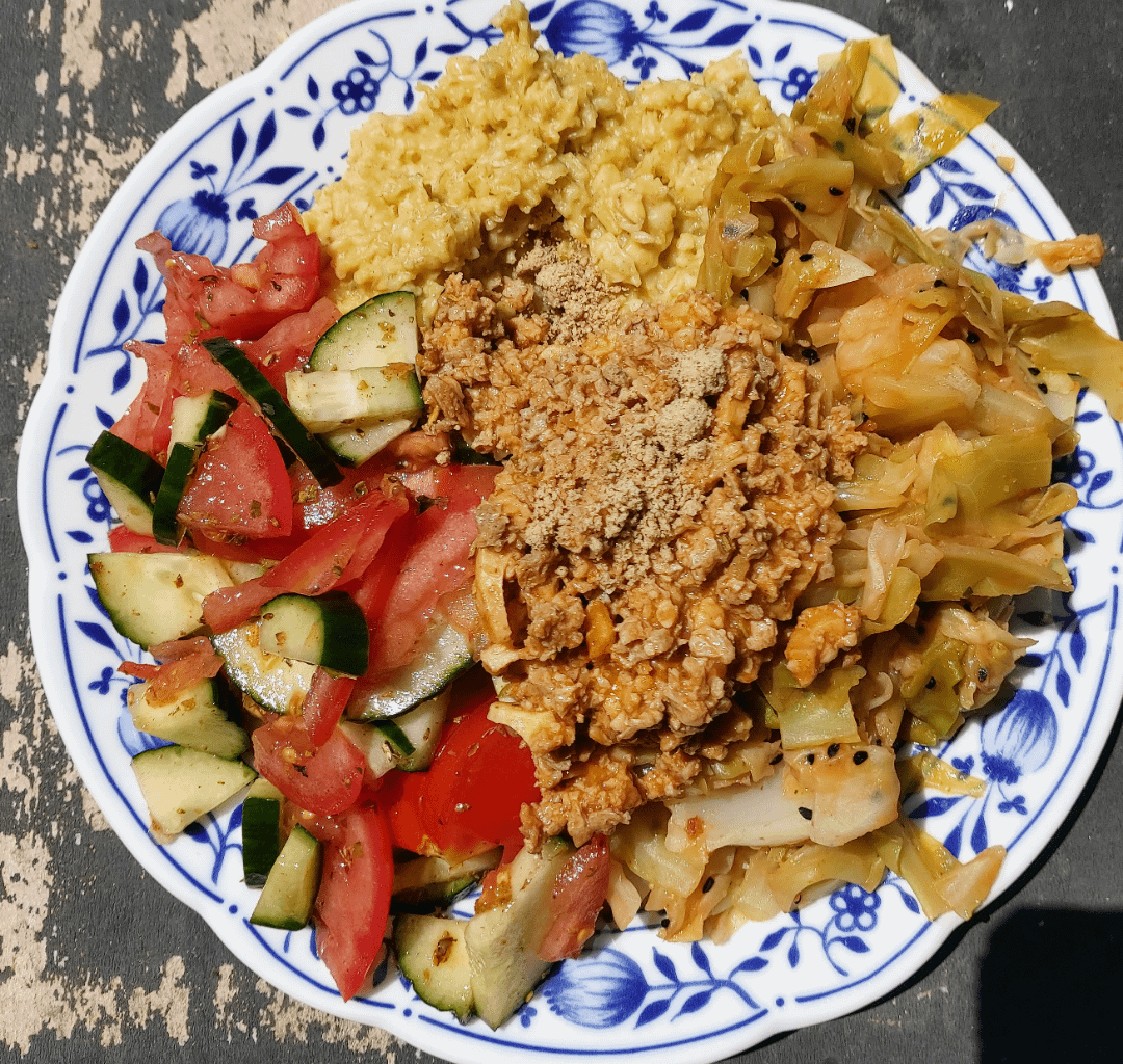 Savory porridge, vegan protein sauce, tomato and cucumber salad, cabbage.