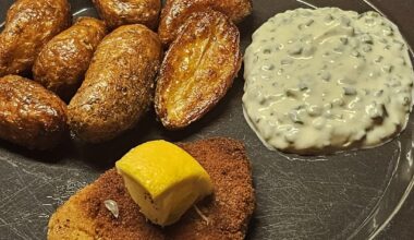 Schnitzel, accompanied by fried potatoes and a homemade chive-based sourcream sauce as a dip with the potatoes