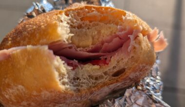 Homemade bread roll with cherry tomatoes and prosciutto cotto.