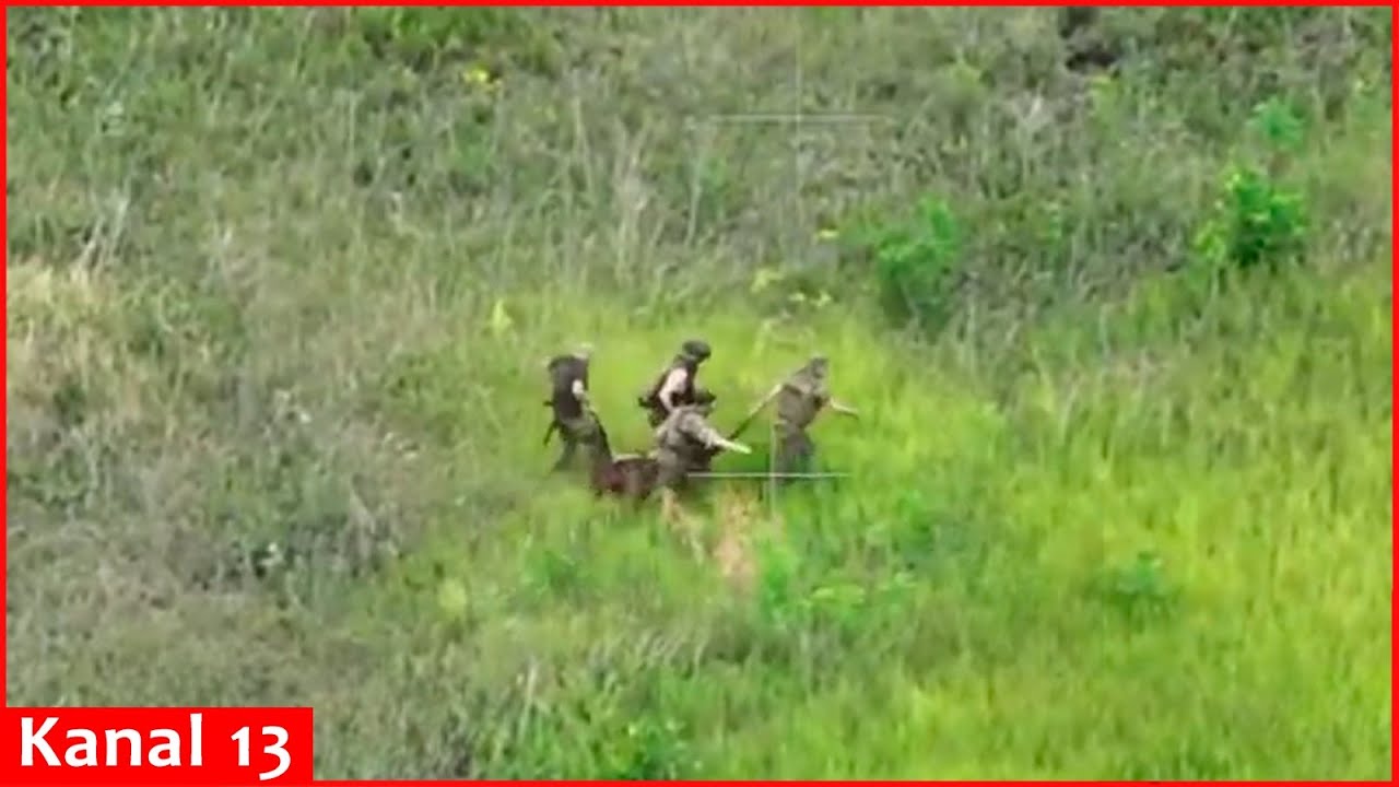 Russian soldiers evacuate their wounded soldiers in an open and mined area