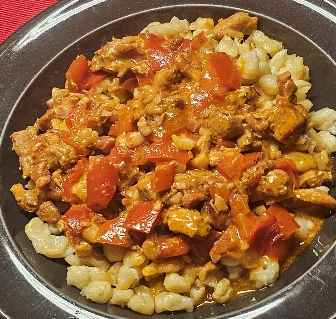 Geschnetzeltes (thin strips of meat, here pork, cooked in a creamy sauce) with peppers, on homemade Spätzle