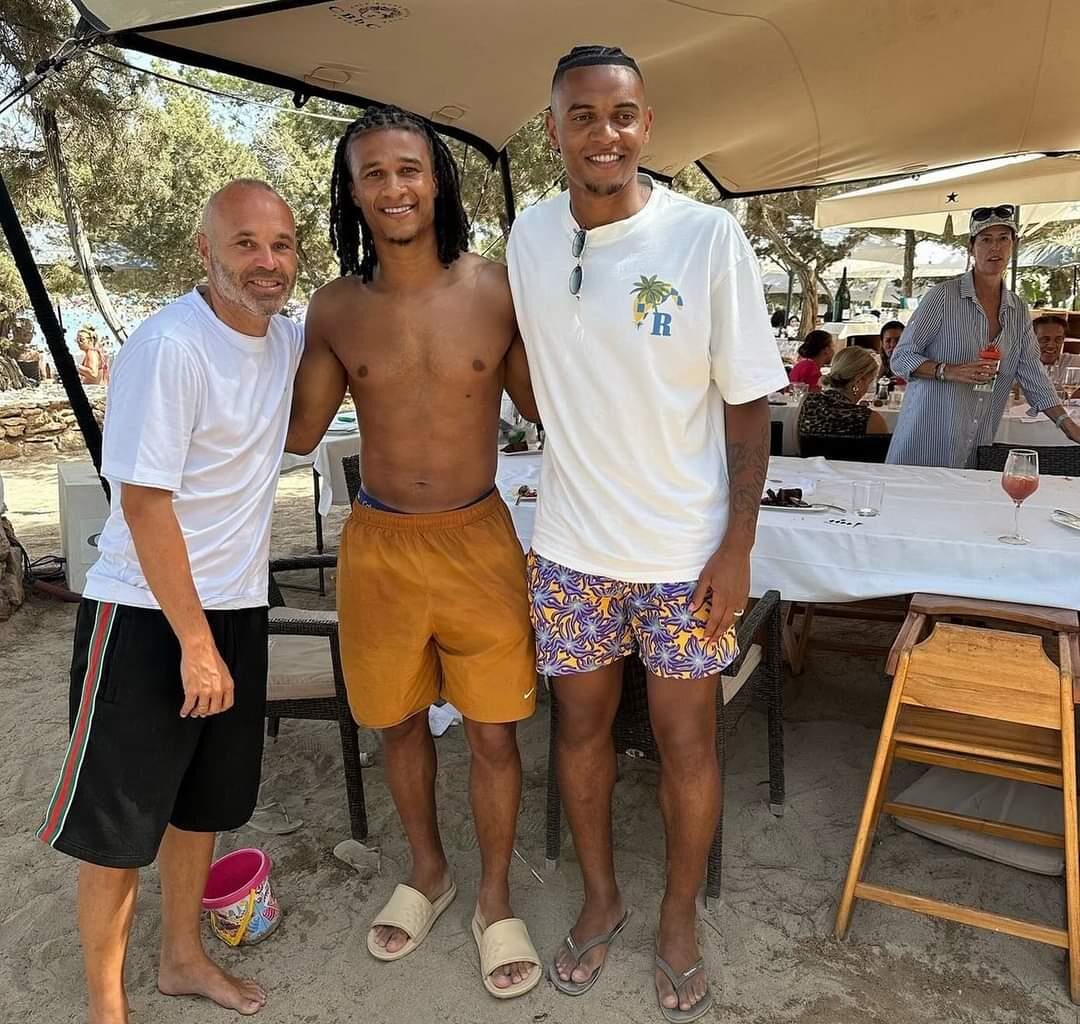 Nathan Aké and Manuel Akanji posing for a photograph with a fan on their holidays