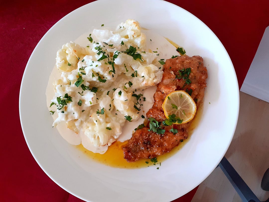 Breading chicken breast in parmesan cheese, lemon butter sauce and chilli.Cauliflower in cheese sauce