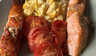 Harissa and lemon garlic salmon fillets with scrambled eggs and grilled tomatoes.