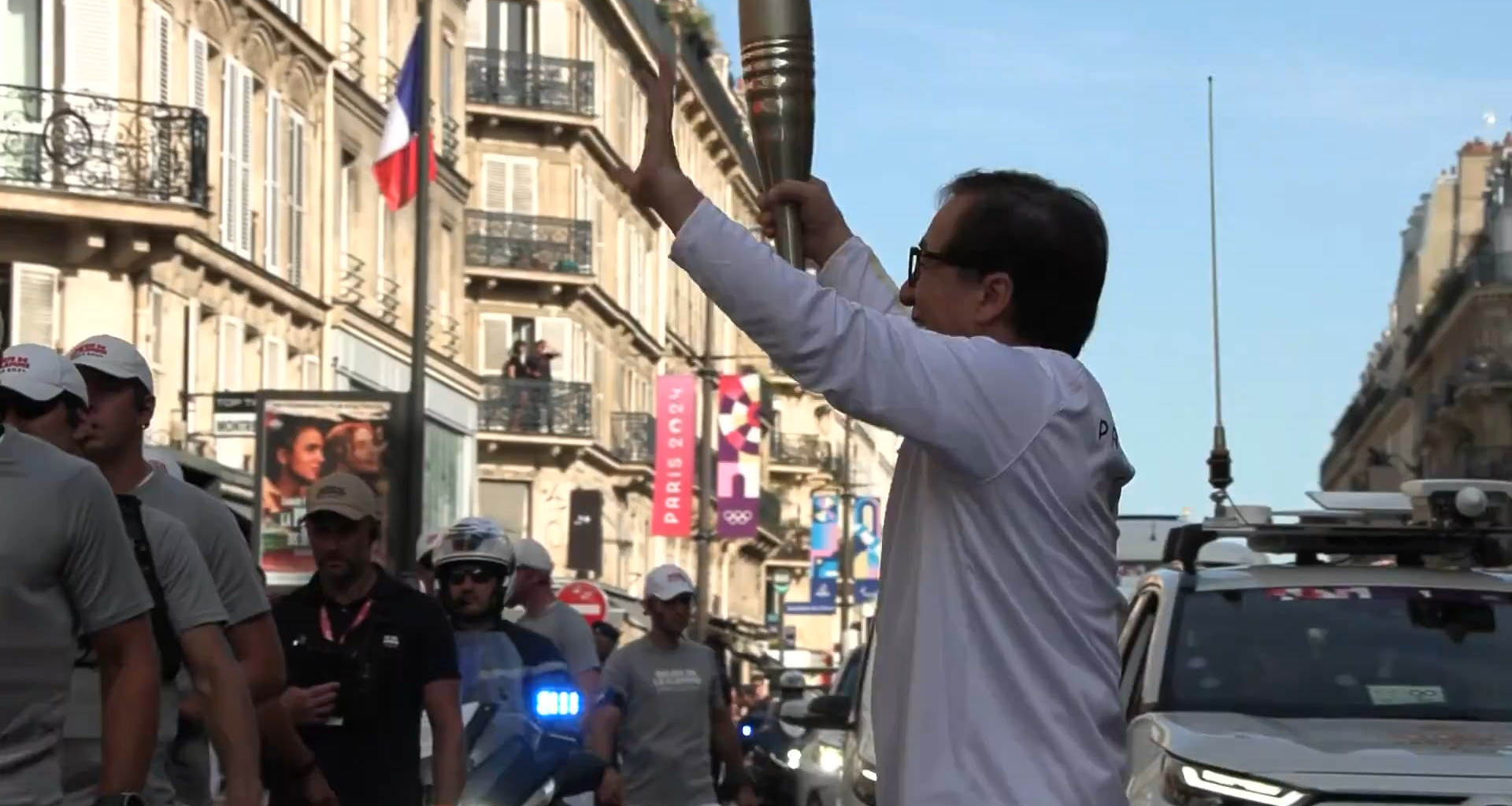 Jackie Chan carrying the Paralympic torch through Paris